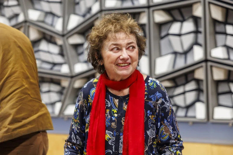 Starosta Jana Boušková se usmívá před abstraktním pozadím.