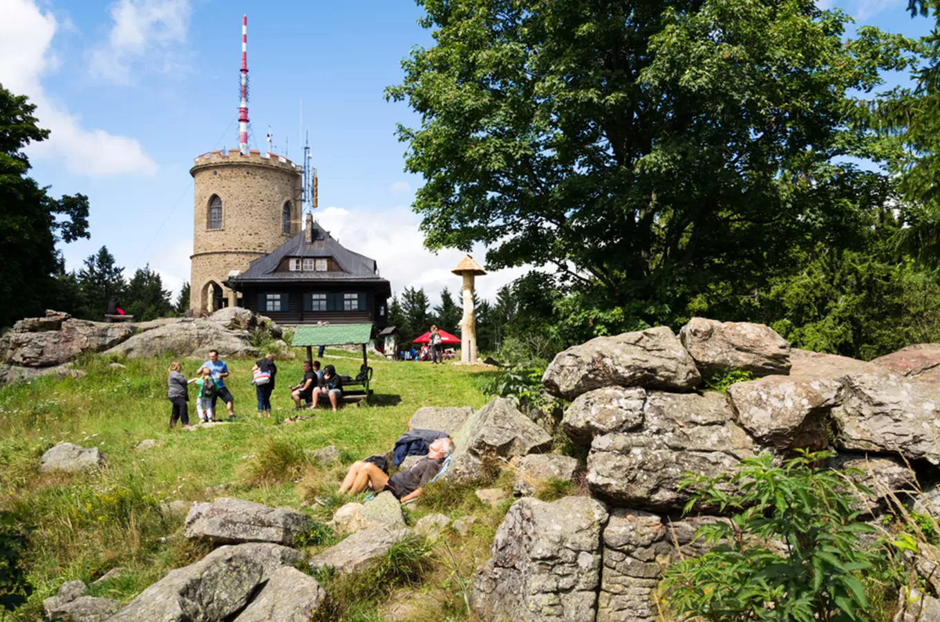 Turisté u rozhledny Kletecké v Českém lese na slunný den.