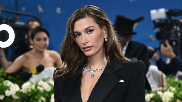 Hailey Bieber na události v černém obleku s diamantovým náhrdelníkem.