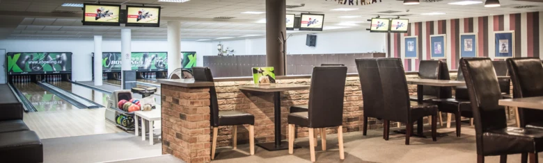 Vnitřek bowlincentra s dráhami a stoly pro rodiny.