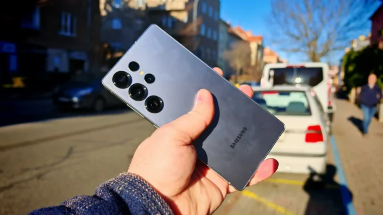 Ruka drží tmavě šedý smartphone Samsung s výraznou zadní kamerou.