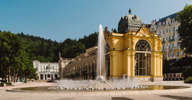 Žlutý palác lázeňského města Mariánské Lázně s fontánou.