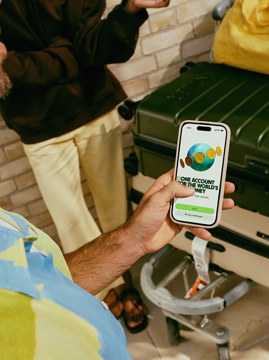 Ruka drží telefon s aplikací pro mezinárodní převod měny