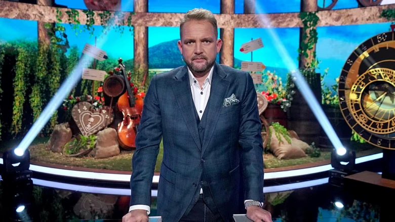 Libor Bouček v televizní studii s nástroji na pozadí.
