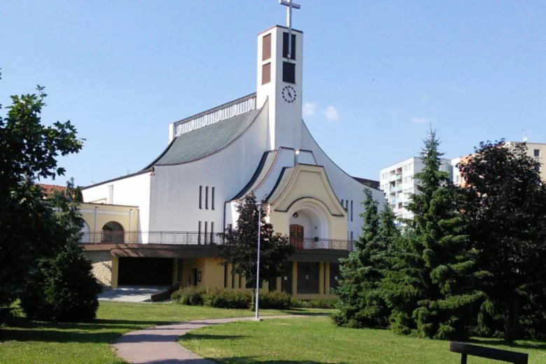 Moderní kostel v Otrokovicích na pozadí zelené zahrady.