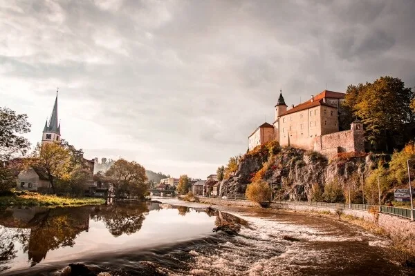 Zámek v Ledči nad Sázavou s řekou Sázkou na pozadí.