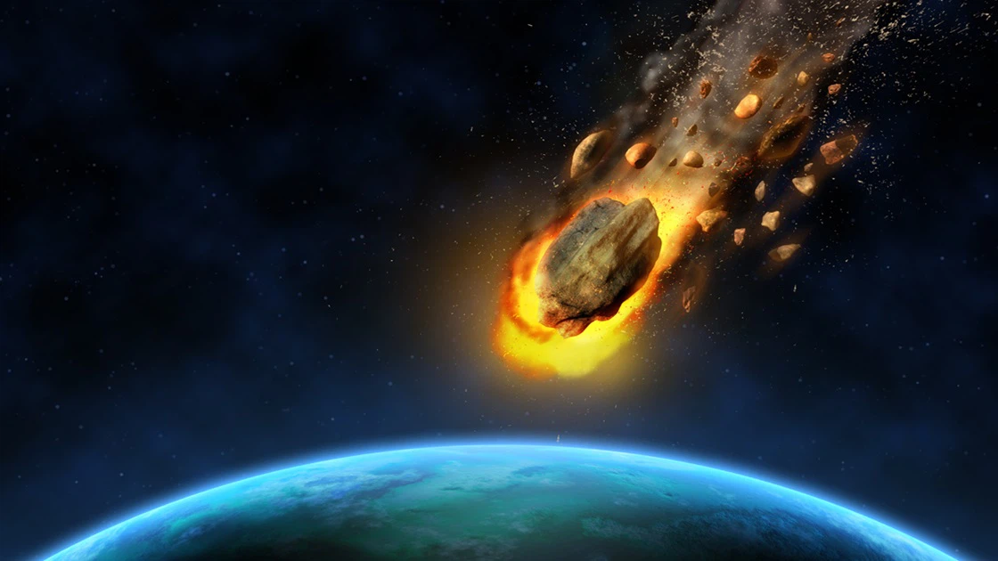 Meteorit hoří při vstupu do atmosféry Země s menšími úlomky.