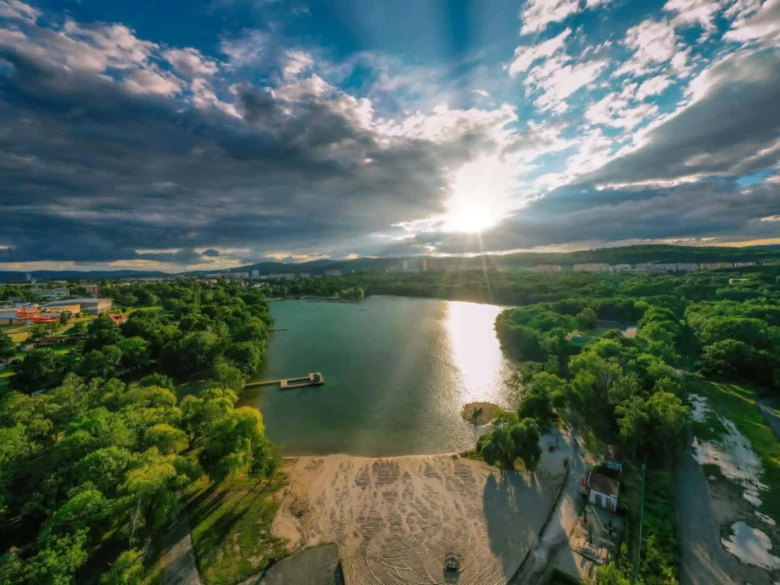 Vzdušný pohled na Kamencové jezero v Chomutově s okolní zelení.