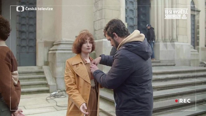 Scéna natáčení filmu před historickou budovou s kamerou.