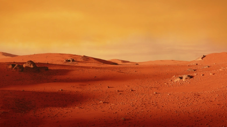 Povrch planety Mars s červenou pískovou pouští a kopci.