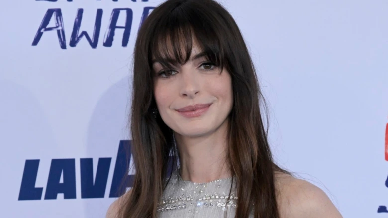 Portrét herečky Anne Hathaway na události s úsměvem.