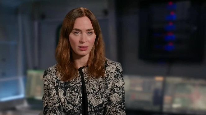 Portrét herečky Emily Blunt v černobílé vestě.