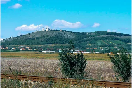 Pohled na kopci s hradem v Mikulově pod modrou oblohou.
