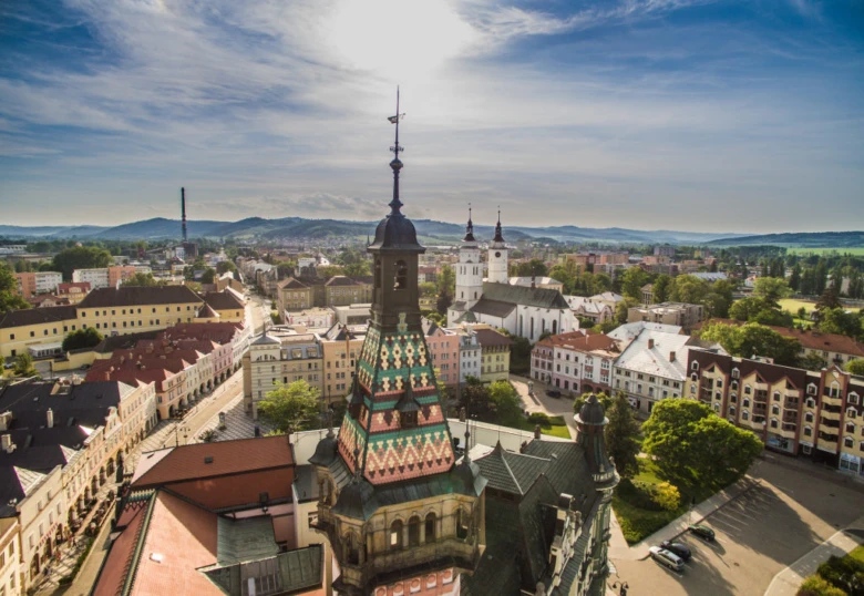 Pohled na náměstí v Krnově s barevnou věží kostela.