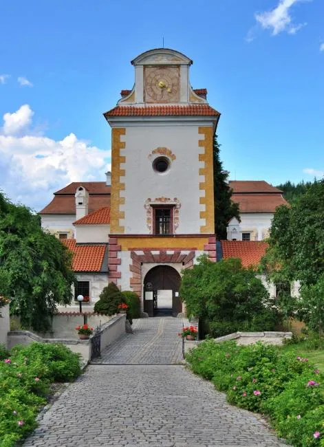 Vstupní brána zámku Kratochvíle v Netolicích s kamennou dlažbou.