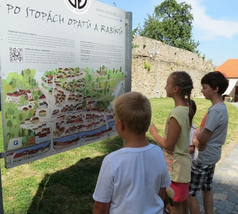 Děti se dívají na historickou mapu města v areálu hradby.