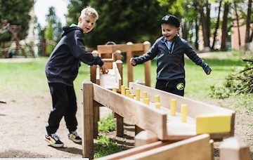 Children playing with ball track outdoors