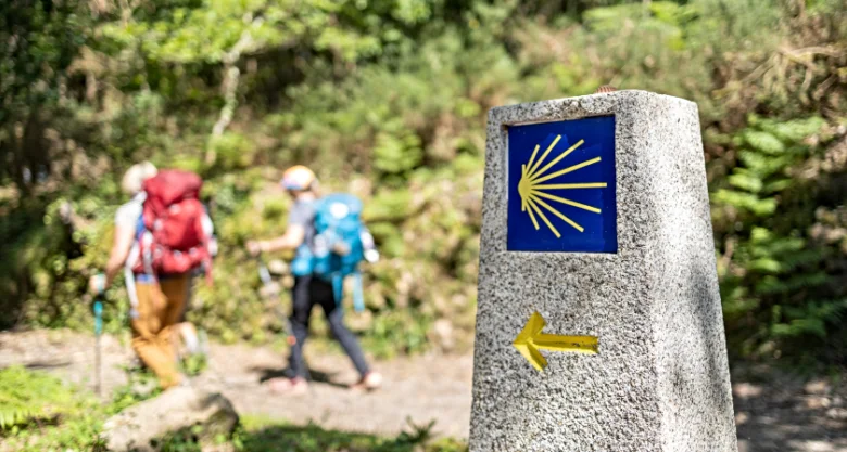 Kamenný sloup s modrým štítem se skořepinou na poutní cestě do Santiaga de Compostela