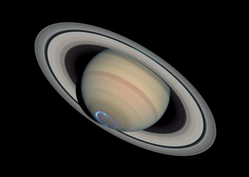 Planeta Saturn s prstenci na černém pozadí.