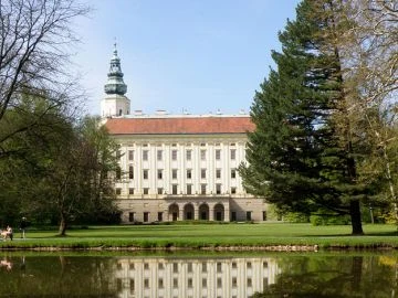Zámek v Kroměříži s parkem odrazem ve vodě.