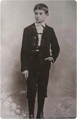Mladý Franz Kafka v formálním obleku na staré fotografii.