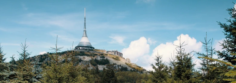Teletelem na kopci v Libereckém kraji s lesy pod ním.