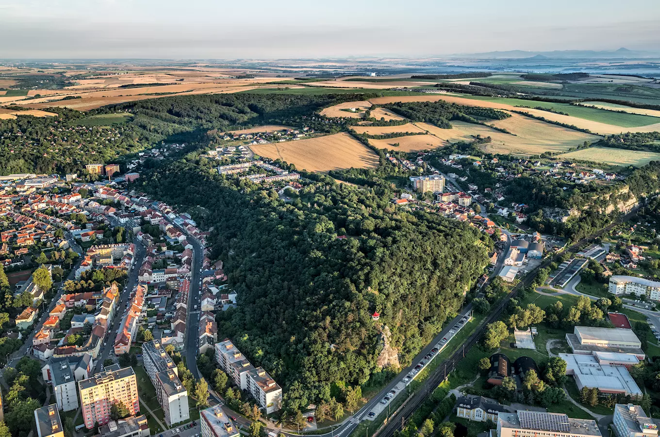 Vzdušný pohled na město Kralupy nad Vltavou s okolní krajinou.