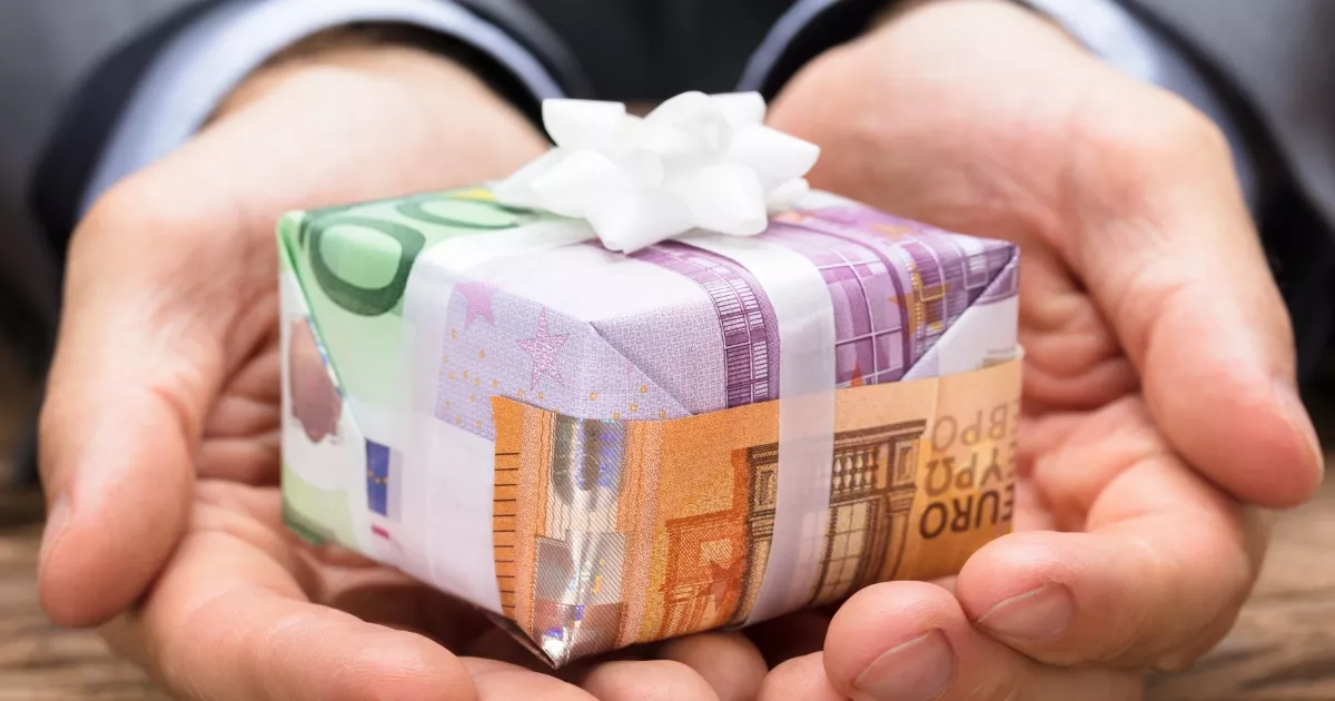 Ruční dárky zhotovené z eurobankovek s bílou mašlí.