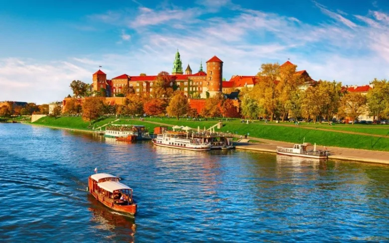 Zámek Wawel nad řekou Visla v Polsku s loděmi.
