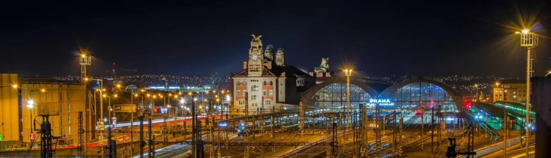 Noční pohled na hlavní nádraží v Praze s vlaky.