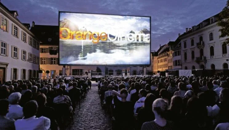 Venkovní kino v Praze s diváky u velkého plátna.