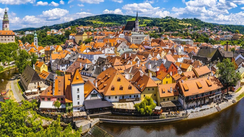 Panoramický pohled na historické město s řekou a kopci v jižních Čechách.