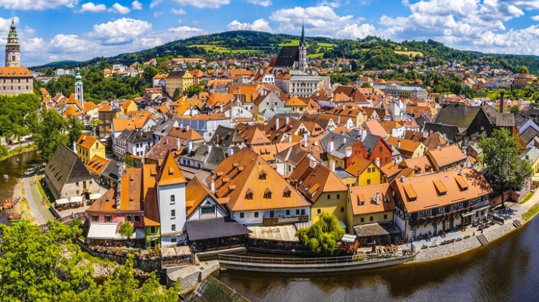 Historické město s řekou v jižních Čechách pod modrou oblohou.