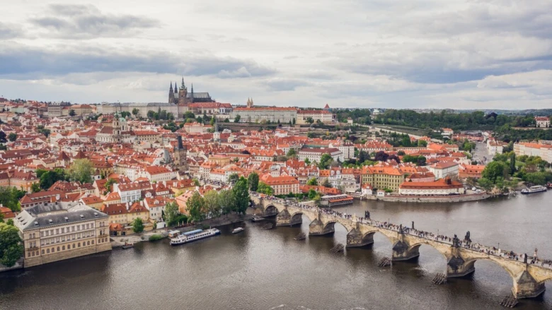Karlův most a Pražský hrad s červenými střechami.