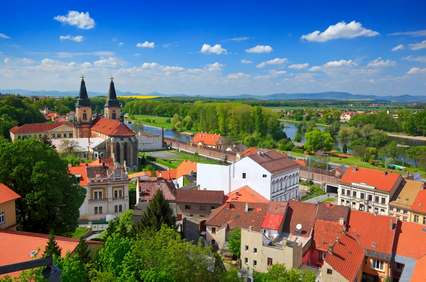 Pohled na město Roudnice nad Labem s kostelem a řekou.