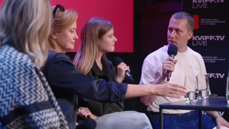 Skupina lidí na pódiu s mikrofony během diskuse.