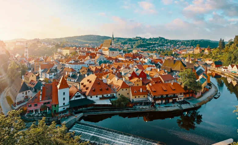 Historické město s červenými střechami leží na řece v jižních Čechách.
