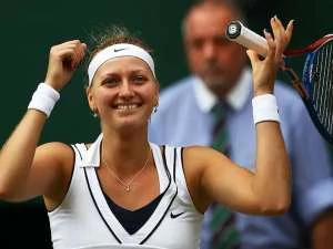 Petra Kvitová vítězně zvedá raketu po bodu na tenisovém turnaji.
