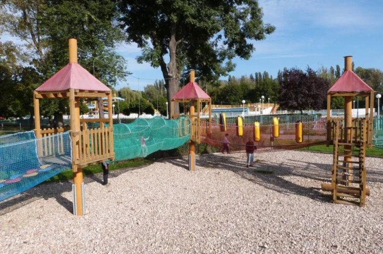 Dřevěné hřiště pro děti s mosty z mříže v pražském parku.