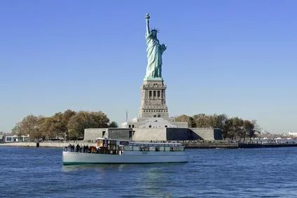 Statue of liberty on pedestal with boat nearby
