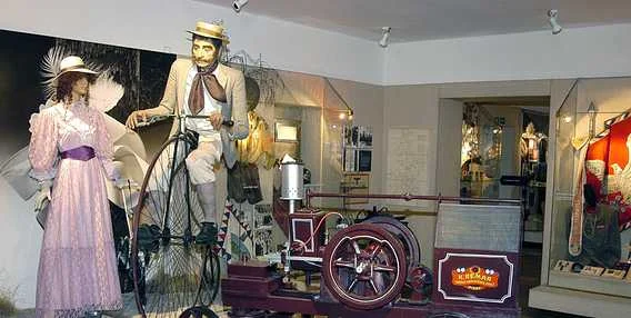 Expozice dopravních prostředků v muzeu s historickými bicykly.