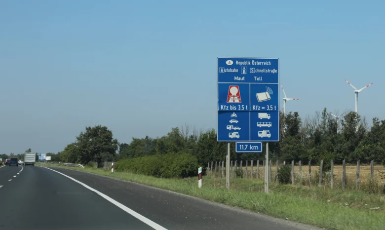 Modlá s dálniční značkou a vítr na pozadí.
