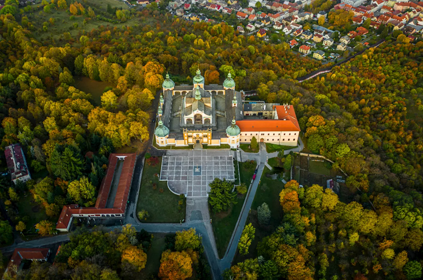 Pohled na barokní klášter v příbramském okolí uprostřed podzimu.