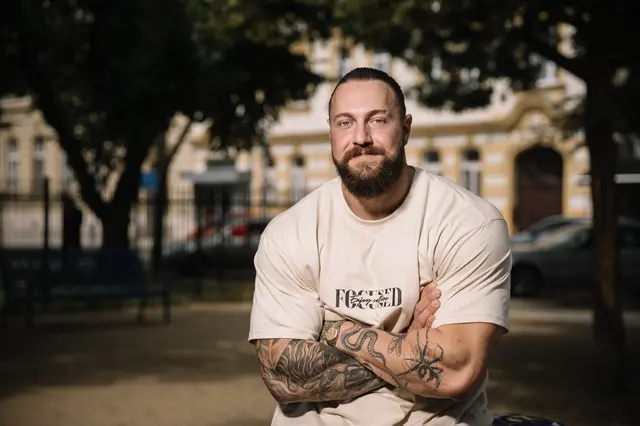 Portrét Jakuba Enzla s tetováními v parku.