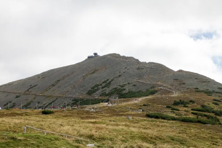 Horský vrchol s chatou a turisty v českých horách