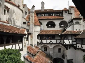 Vnitřní dvůr hradu Drakula s kamennými zdmi a dřevěnými balkony.