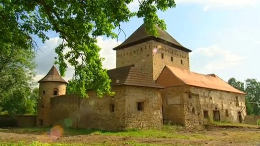 Historická tvrz Divice s věžemi a kamennými zdmi.