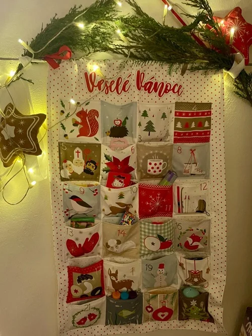 Český vánoční kalendář s výtisky zvířat a dekorací.