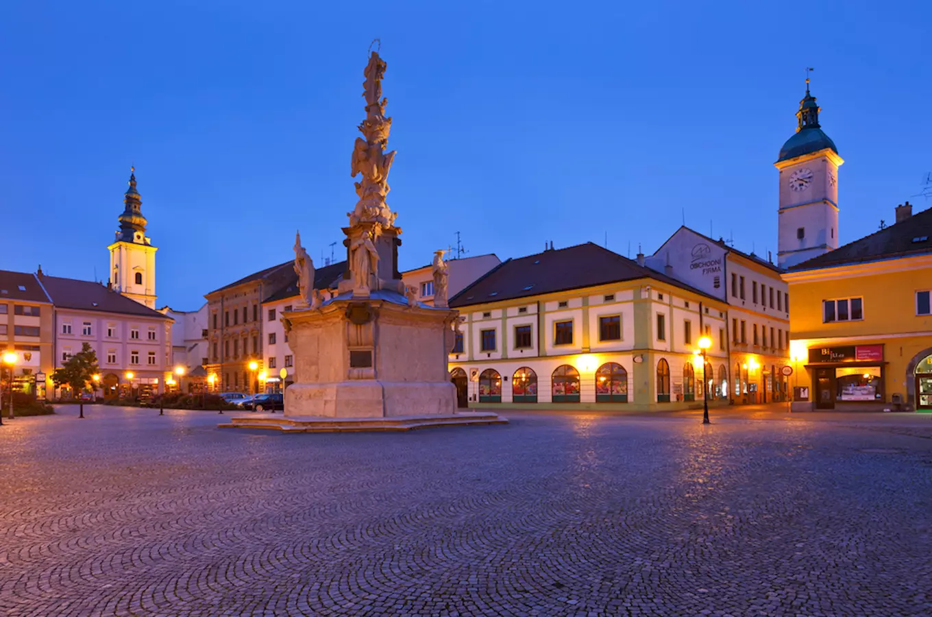 Náměstí v Uherském Hradišti s památníkem a věží kostela.