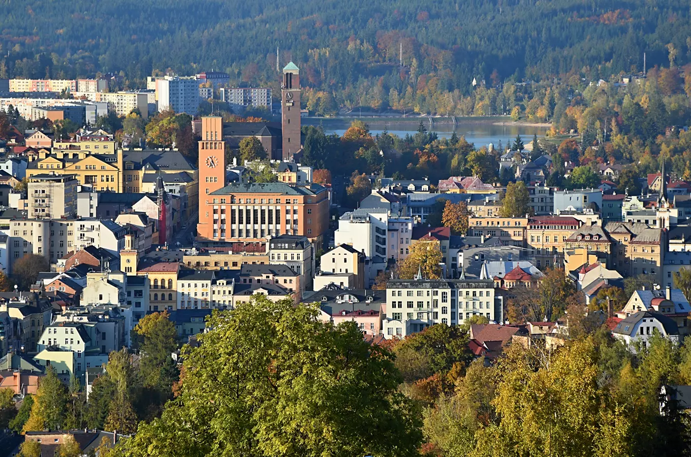 Pohled na město Jablonec nad Nisou s věžemi a lesy.